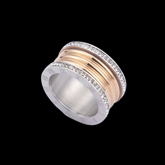 A stainless steel ring with Roman numerals around the top, featuring a gold band and silver accents.